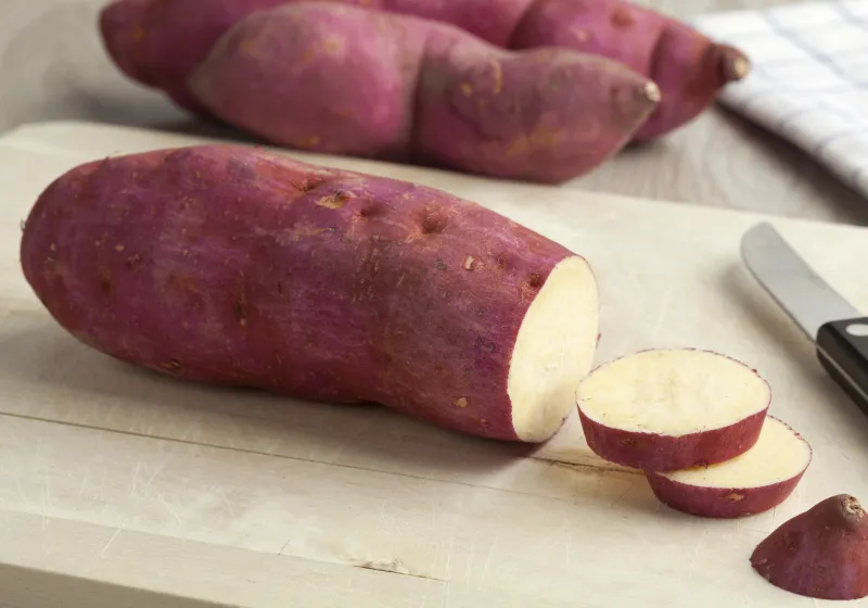 batata doce batatas doce roxa em ciam da tabua com uma faca