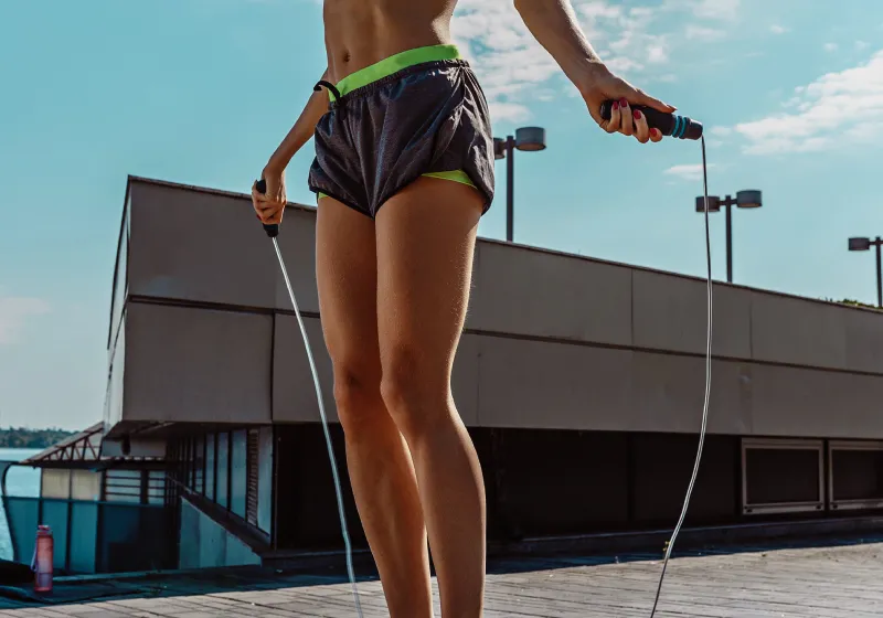 mulher fitness pulando corda ao ar livre