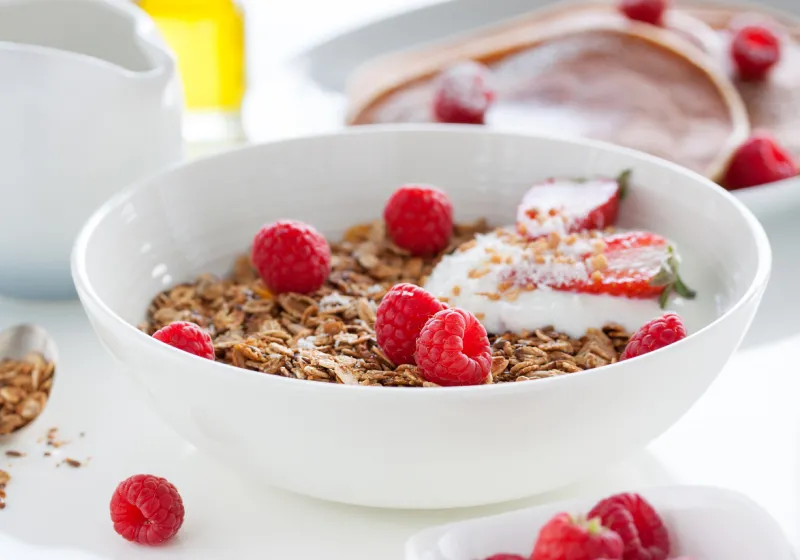 iogurte natural com aveia e frutas tigela com iogurte natural com cereais e framboesas