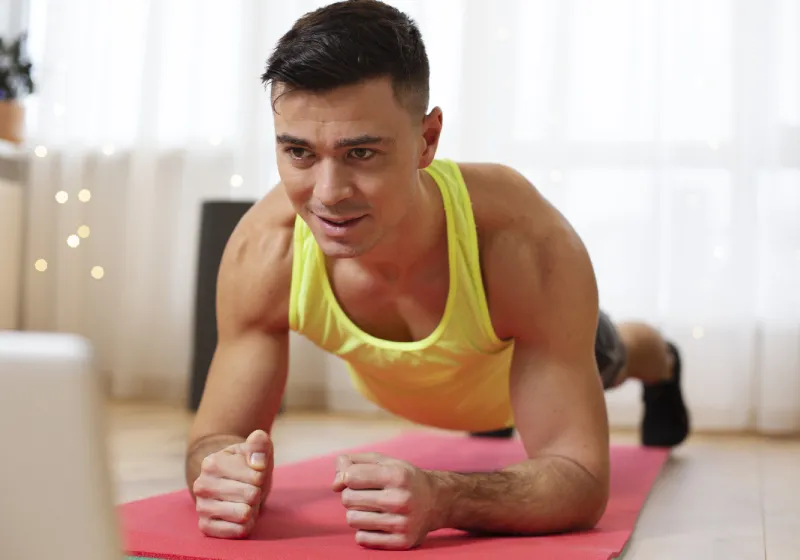 abdominal prancha homem fitness fazendo prancha na frete do notebook