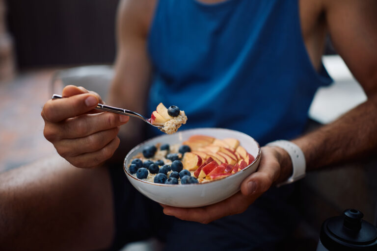 Pessoa comendo mingau de aveia com frutas e blueberries