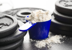 suplemento de glutamina ao lado de pesos de academia