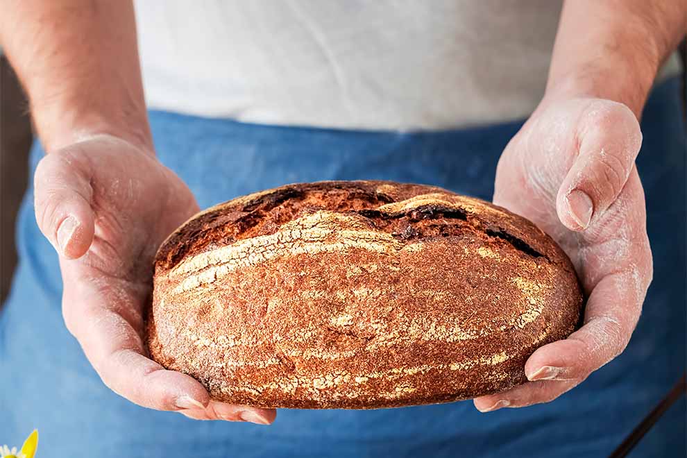 Pão artesanal sendo segurado por um homem