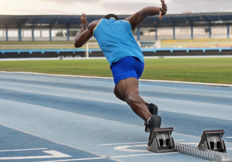 Homem correndo em pista de atletismo
