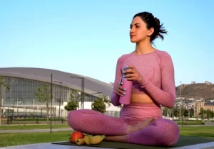 mulher sentada na grama tomando água de manhã