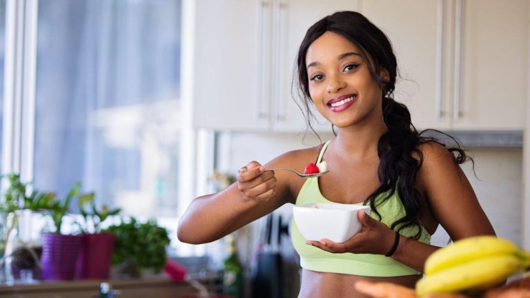 Mulher sorrindo comendo frutas
