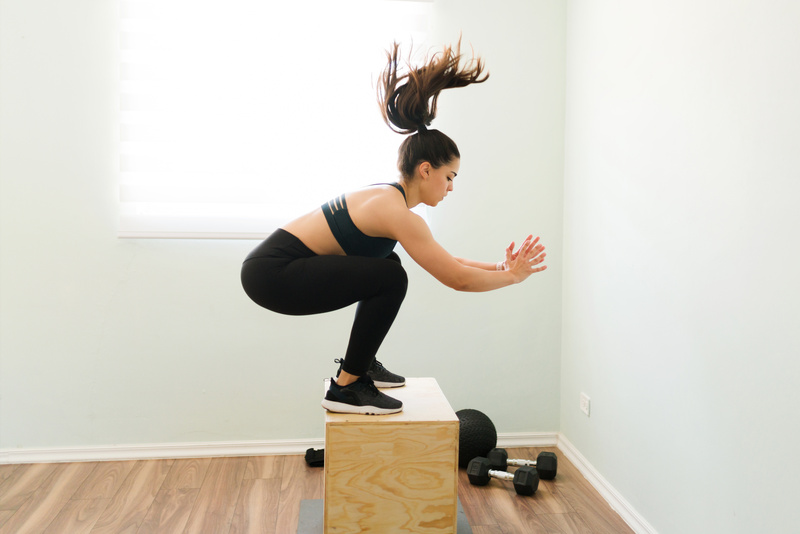 mulher fazendo agachamento com salto na academia