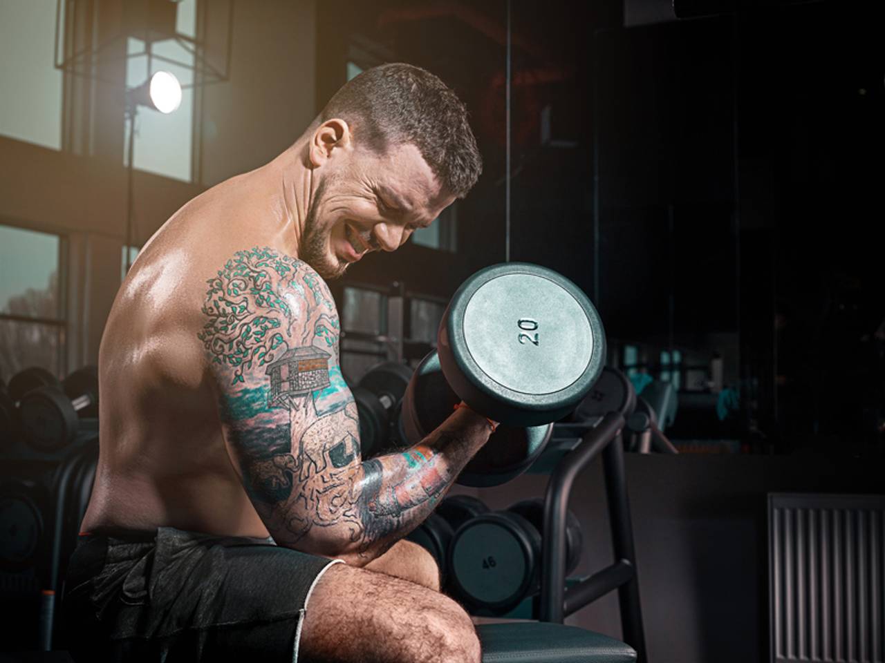 homem na academia levantando halter