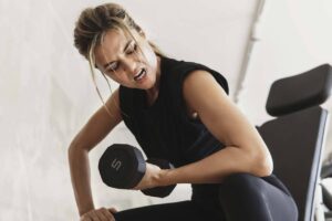 mulher fazendo rosca na academia concentrada