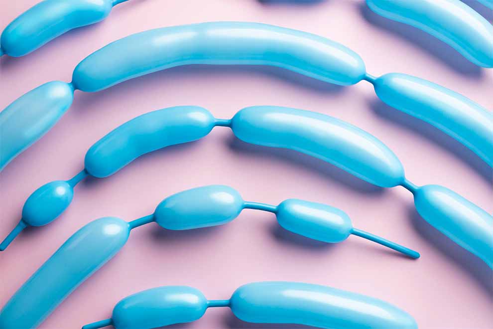 microbiota intestinal introdução microbiotas intestinal feitos em bexigas compridas azul em cima de uma mesa rosa claro