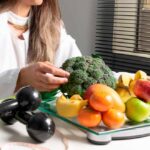 Profissional de saúde com alimentos saudáveis e halteres.