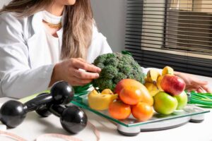 Profissional de saúde com alimentos saudáveis e halteres.