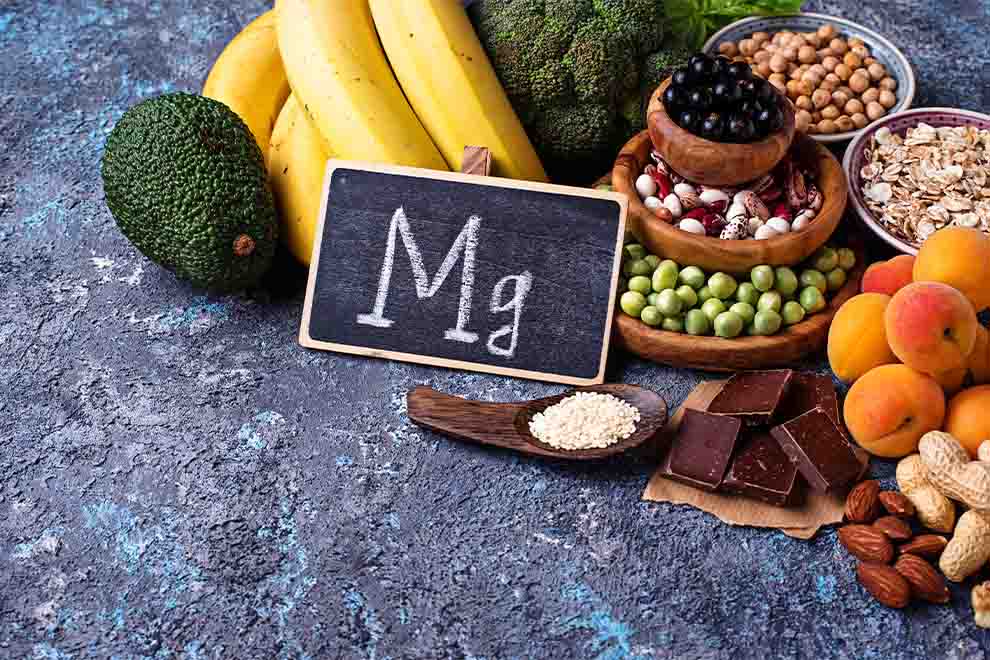 alimentos derivados do magnésio alimentos com magnésio em cima de uma mesa escura com um pequeno quadro escrito em giz na frente