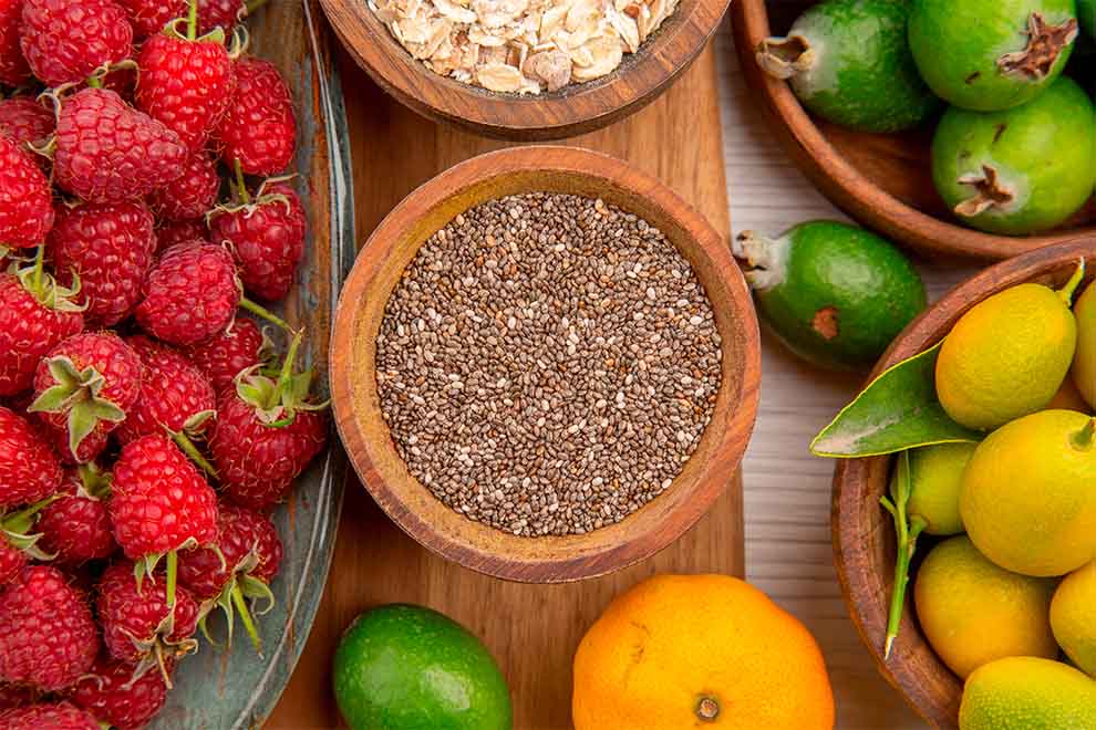 Frutas frescas e sementes em recipientes de madeira