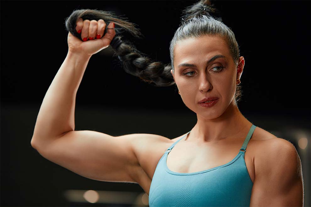 Mulher forte puxando o cabelo em treino