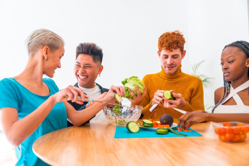 Amigos preparando salada em ambiente alegre