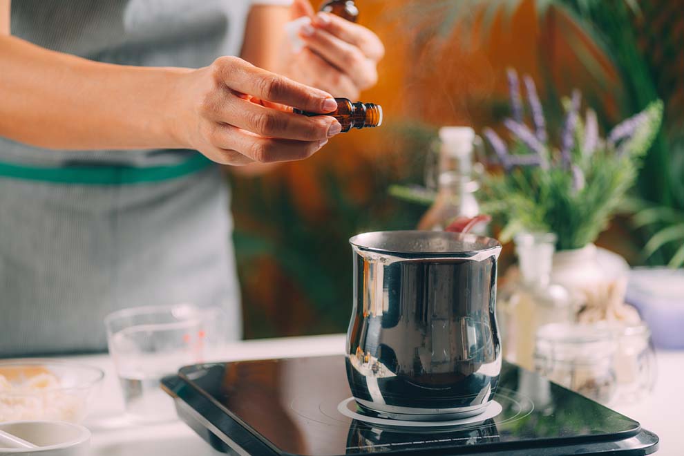 mulher preparando o perfume para a aromaterapia a luz de velas