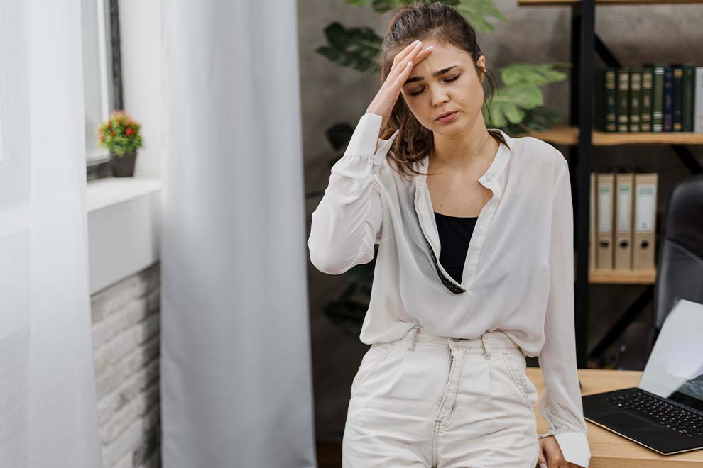 mulher com mão na cabeça estressada no escritorio de seu trabalho