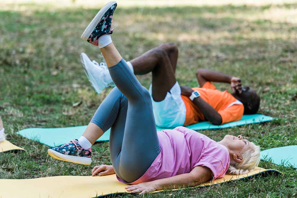 Mulher fazendo exercícios ao ar livre em gramado