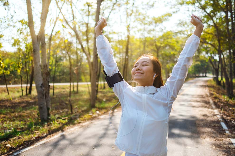 Mulher sorrindo em caminhada ao ar livre.