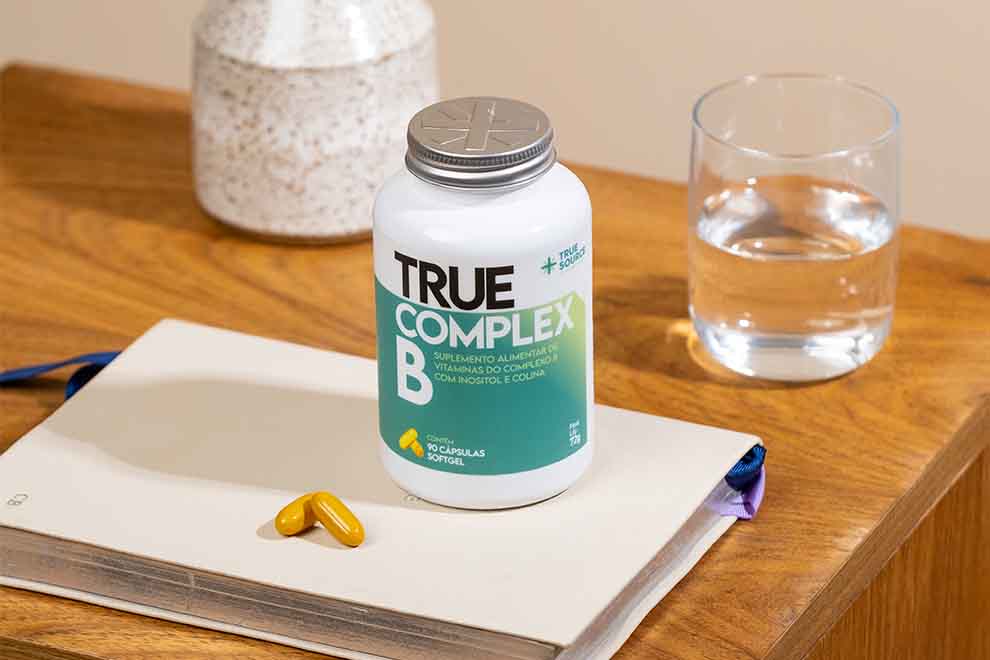 Suplemento True Complex B sobre mesa de madeira